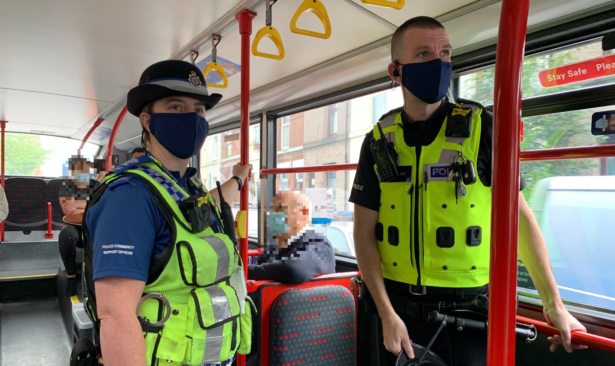 Male and female police offices on public transport wearing face masks