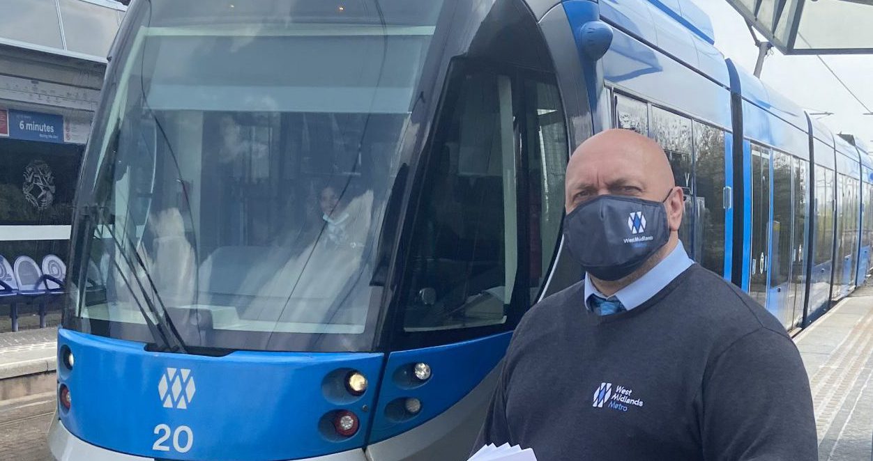 Man standing in front of tram wearing a face mask