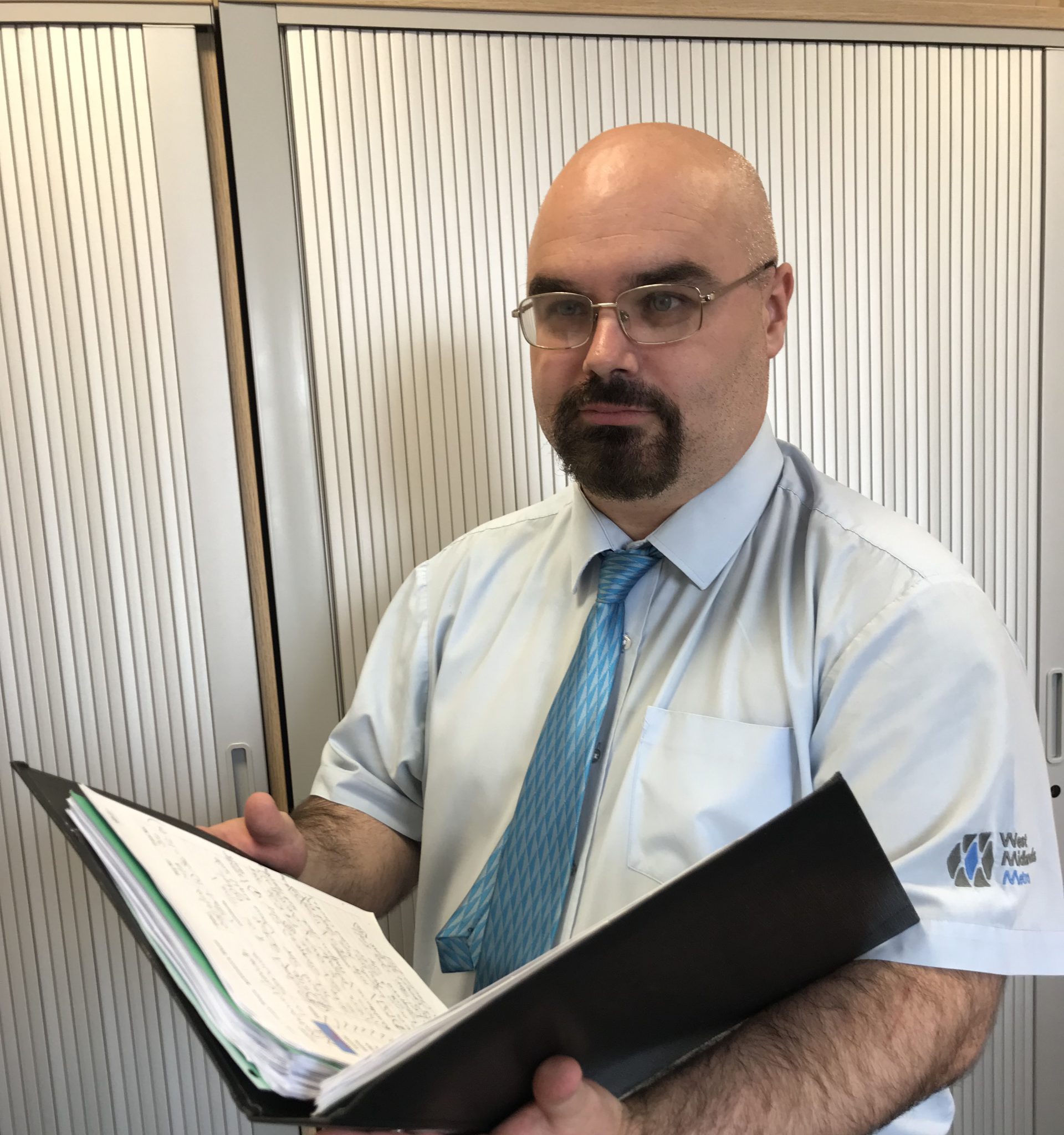 Image of man who works for West Midlands Metro holding a book